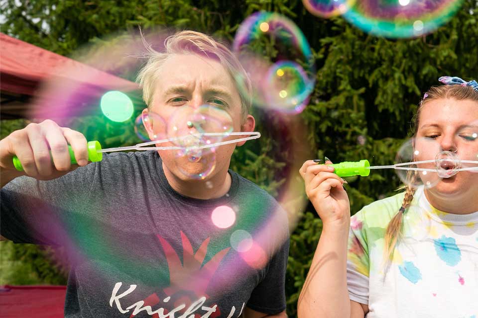 undergraduate students blow bubbles