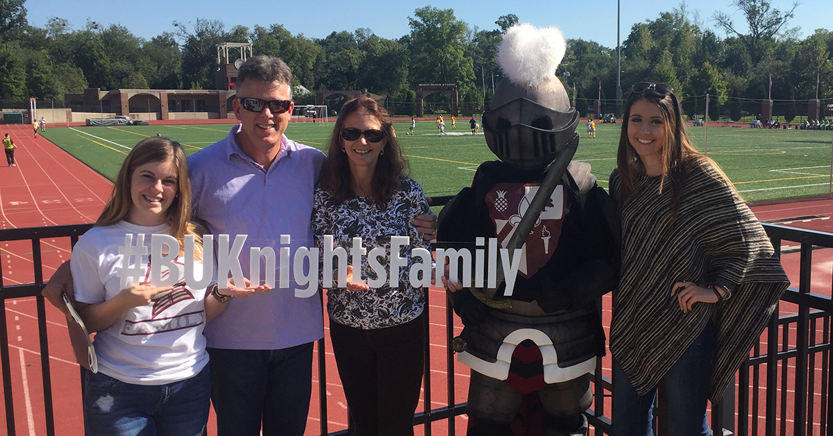 Parents Circle Parents and family hold up a Bellarmine sign by the athletic track