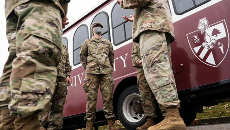 military students dressed in fatigues stand by the bellarmine trolley