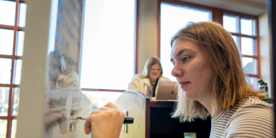 student writes on a whiteboard in class