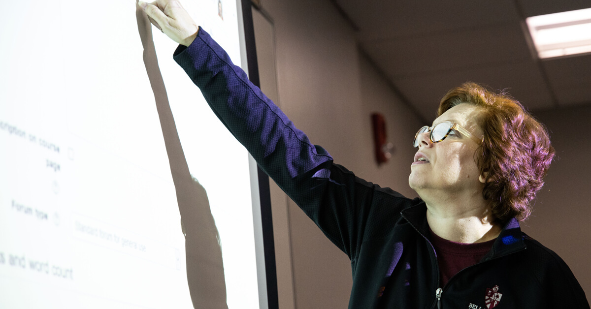 A faculty member writing on a board 