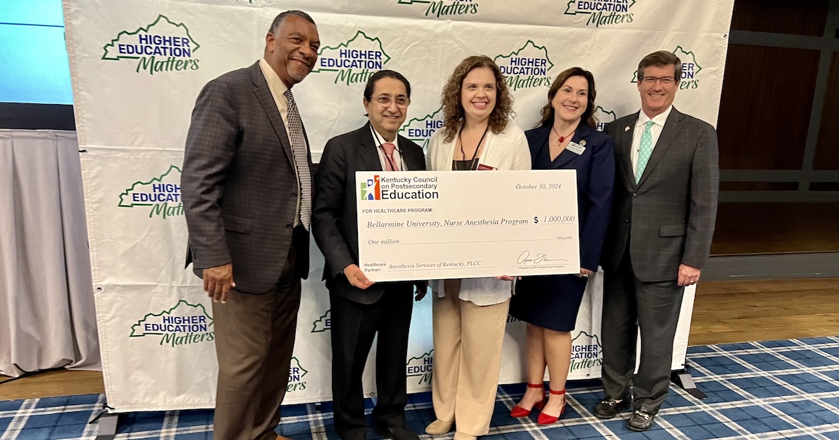 Five people holding a check