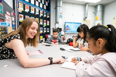 A teacher works with a young student to practice reading