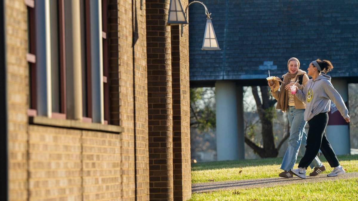 students walk across the quad to the library