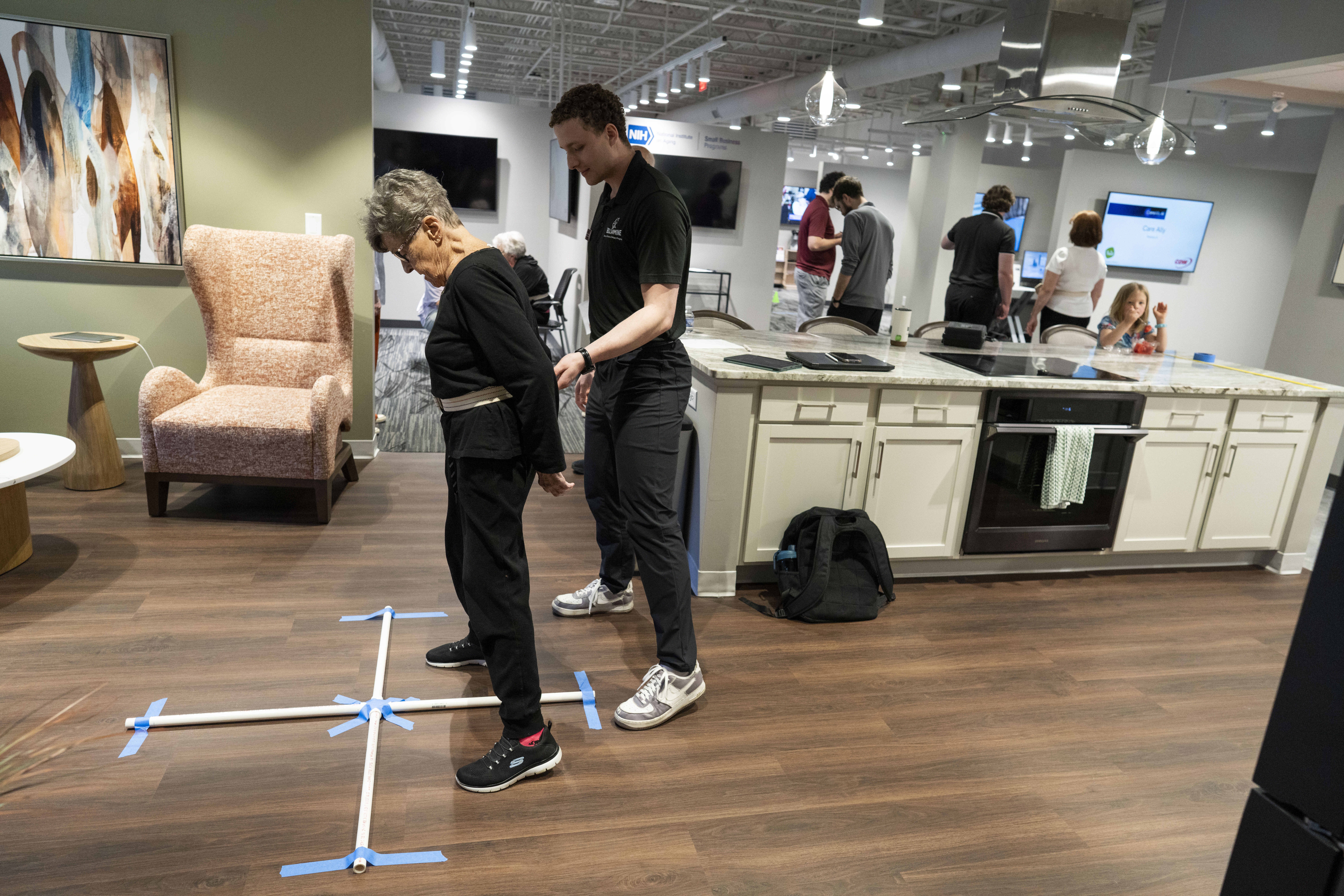 A clinic worker leads a patient through an exercise.