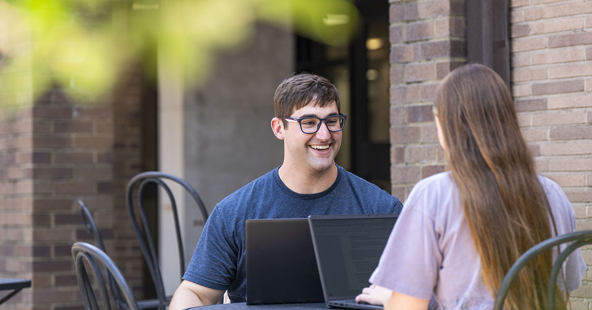 Two Students on Laptops in the Bellarmine Quad