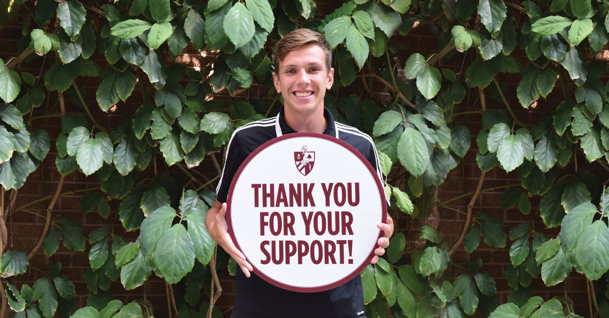 A Student Holding a Sign Thank You For Your Support